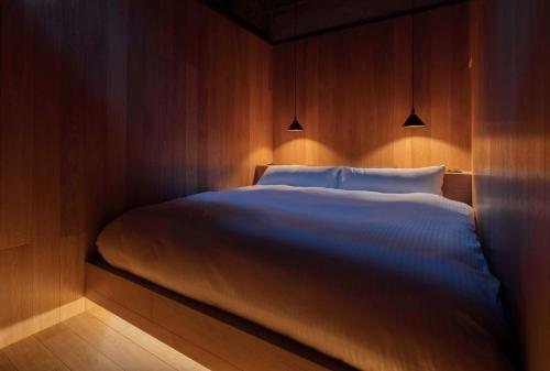 a bedroom with a large bed with lights on it at Maana Kamo in Kyoto