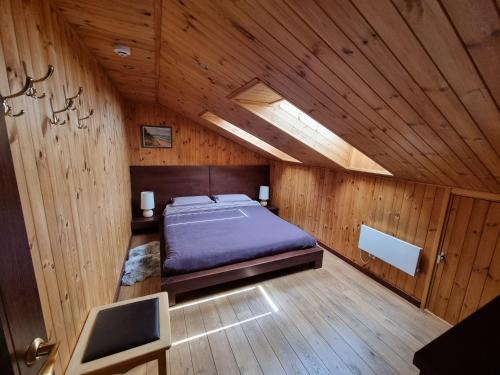a bedroom with a bed in a wooden room at Saules Street Home in Kuldīga