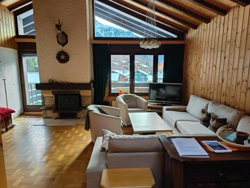 uma sala de estar com um sofá e uma mesa em Haus Azurit Dachwohnung Nr.30 em Grächen