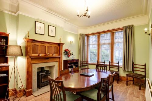 a dining room with a table and a fireplace at Spacious Victorian Townhouse near HCC with off street parking in Harrogate