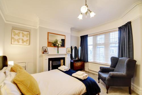 a bedroom with a bed and a chair and a fireplace at Spacious Victorian Townhouse near HCC with off street parking in Harrogate