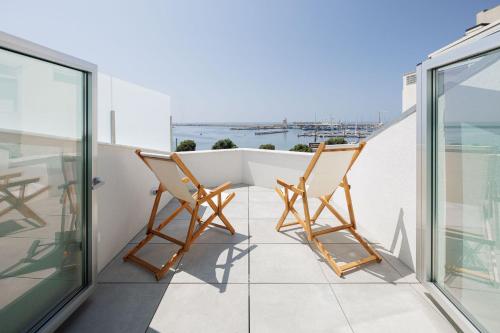 two chairs on a balcony with a view of the ocean at Lapa 84 - seafront house in Póvoa de Varzim