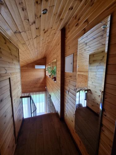 a hallway of a wooden house with wooden walls at Saules Street Home in Kuldīga