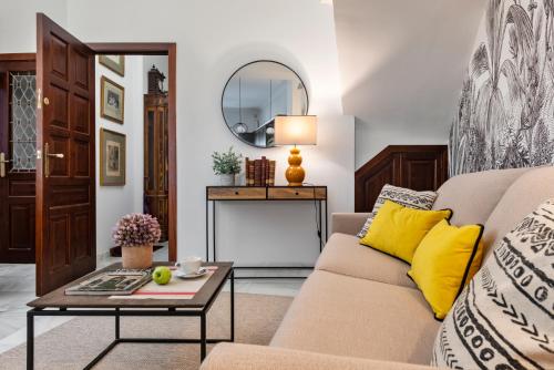 Magno Apartments Hernando Colón في إشبيلية: غرفة معيشة مع أريكة وطاولة