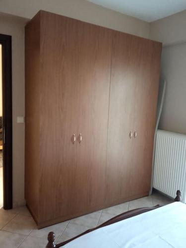 a large wooden cabinet in a bedroom with a bed at ΔΙΑΜΈΡΙΣΜΑ ΜΕΝΤΗΣ in Igoumenitsa