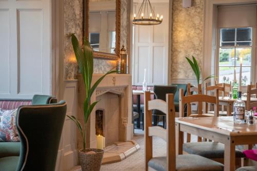 a dining room with a table and a fireplace at The Woodside in Doune