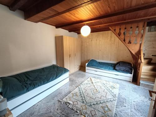 2 camas en una habitación con techos de madera en Appartement cozy 100m2 dans chalet savoyard, en Magland