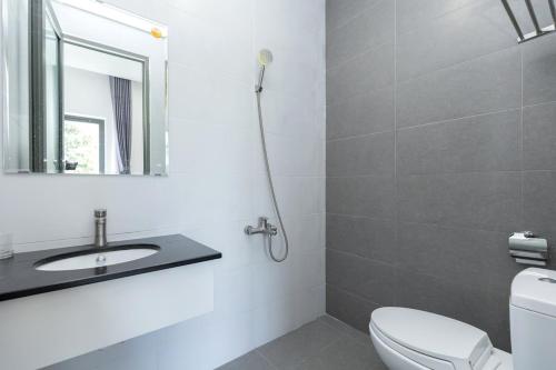 a bathroom with a toilet and a sink and a mirror at Minh Phước Villa in Vung Tau