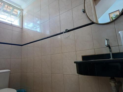 uma casa de banho com um espelho e um lavatório em Diversão, churrasco e piscina - Praia de Ipitanga em Salvador