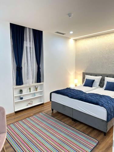 a bedroom with a bed and a window and a rug at KARAULA Apartments in Sarajevo
