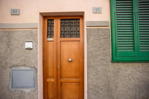 une porte en bois et une fenêtre verte sur un bâtiment dans l'établissement Bilocale La Tonnina - Goelba, à Portoferraio