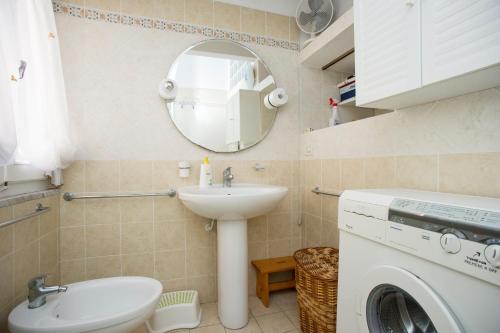 a bathroom with a sink and a washing machine at Bilocale La Tonnina - Goelba in Portoferraio
