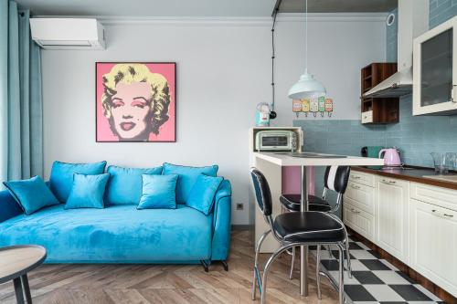 a living room with a blue couch and a kitchen at RentPlanet - Apartamenty Zarembowicza in Wrocław