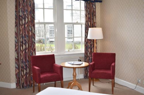 a room with two chairs and a table and a window at Green Hotel in Kinross