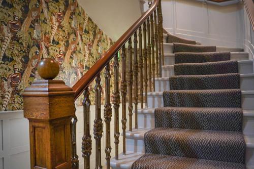a staircase in a home with a patterned wall at The Woodside in Doune