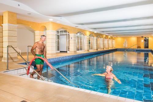 a man and a child in a swimming pool at Gesundheit & Wellness Resort Bad Mitterndorf in Bad Mitterndorf