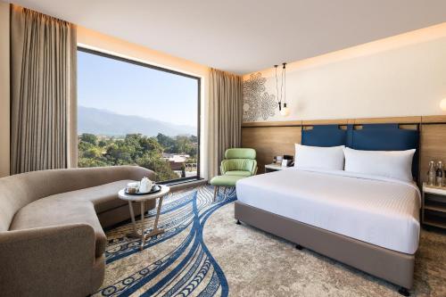 a hotel room with a bed and a large window at Fortune Walkway Mall, Haldwani - Member ITC Hotels' Group in Haldwāni