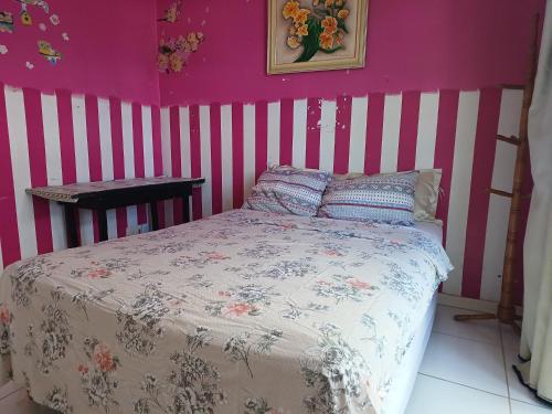 a bedroom with a bed with pink and white stripes at Diversão, churrasco e piscina - Praia de Ipitanga in Salvador