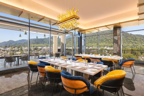 a dining room with tables and chairs and large windows at Fortune Walkway Mall, Haldwani - Member ITC Hotels' Group in Haldwāni