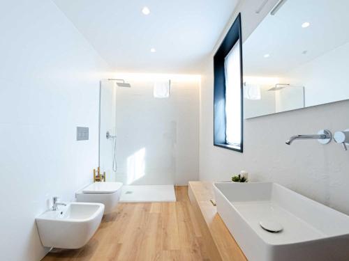 a white bathroom with two sinks and a mirror at Pascià Boutique Hotel in Ragalna