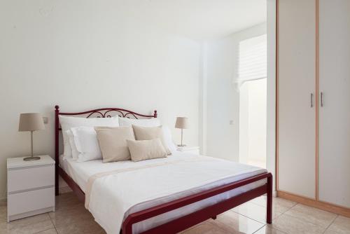a bedroom with a large bed with white sheets and pillows at Aphaia Villa & Residences Aegina in Agia Marina Aegina