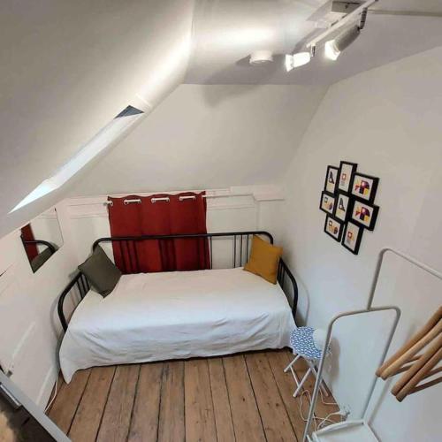 une petite chambre avec un lit dans un grenier dans l'établissement Maison H 3 personnes Honfleur, à Honfleur