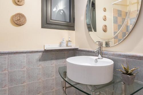 a bathroom with a white sink and a mirror at Aphaia Villa & Residences Aegina in Agia Marina Aegina