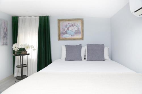a bedroom with a white bed and green curtains at Ditto Flats in Istanbul