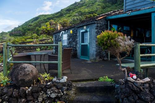 ein Haus mit einer grünen Tür und einem Berg in der Unterkunft Casa do Caramba - The Dream House in São Roque do Pico