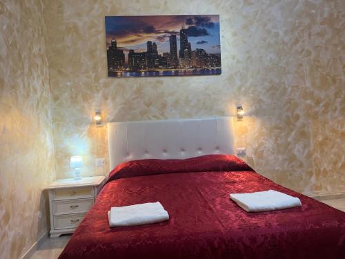 a bedroom with a red bed with two towels on it at Monlight Guest House in Rome