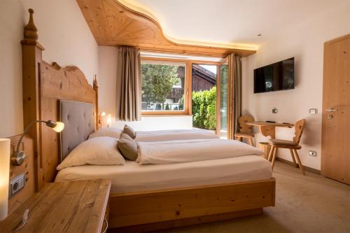 - une chambre avec un grand lit et une fenêtre dans l'établissement Garni Alba Bed & Breakfast, à Ortisei