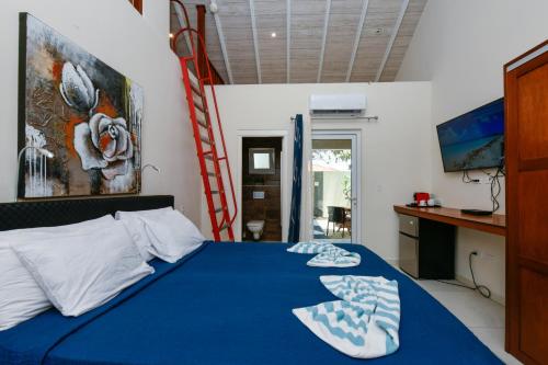 a bedroom with a blue bed with a ladder at Boutique Hotel Swiss Paradise Aruba Villas and Suites in Palm-Eagle Beach
