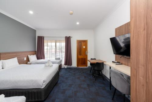a hotel room with two beds and a flat screen tv at Yarra Valley Motel in Lilydale
