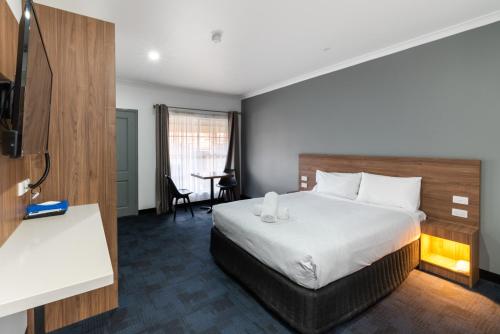 a hotel room with a bed and a desk at Yarra Valley Motel in Lilydale