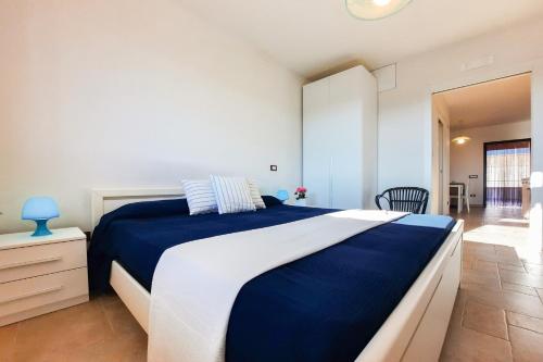 a bedroom with a large blue and white bed at Appartamento Corallo - MyHo Casa in Torre Canne