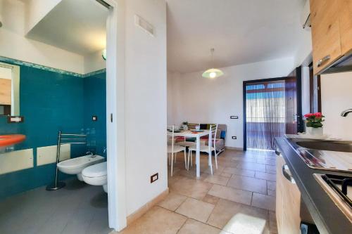 a bathroom with a toilet and a table in a room at Appartamento Corallo - MyHo Casa in Torre Canne