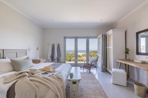 a bedroom with a bed and a view of the ocean at Ocean Mist in Plettenberg Bay