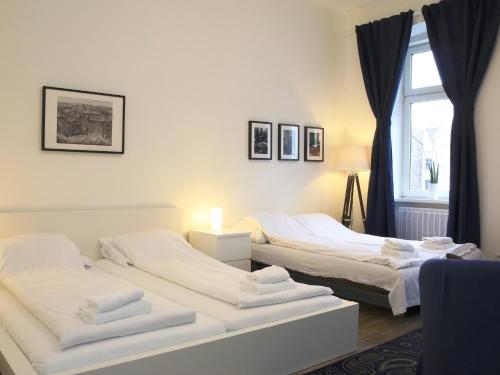 2 weiße Betten in einem Zimmer mit Fenster in der Unterkunft Flatprovider Comfort Eduard Apartment - contactless check in in Wien