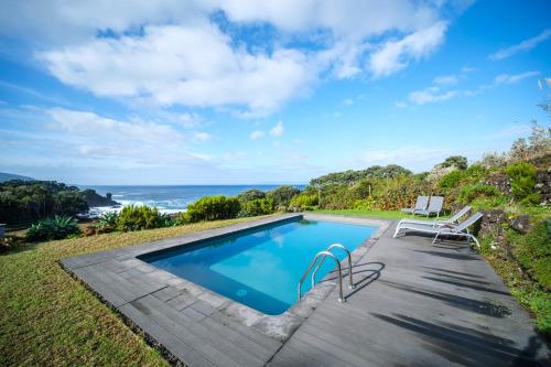 a pool with a view of the ocean at Stone Home Casa do Caisinho Pico island in Terra Alta