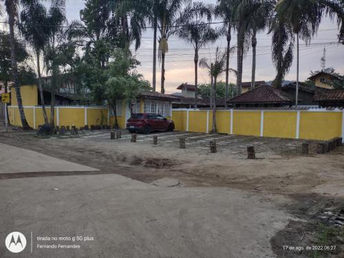 une voiture garée dans un parking à côté d'un bâtiment jaune dans l'établissement solar das margaridas, à Parati