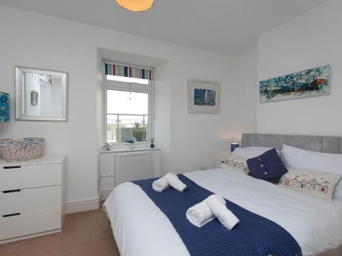 a bedroom with a bed with towels on it at Pass the Keys Modern 2 Bedroom Apartment with stunning Sea Views in Trearddur