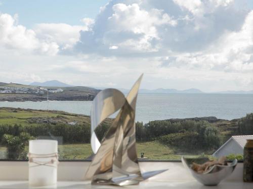a table with two silver trophies on a table with a view of the ocean at Pass the Keys Modern 2 Bedroom Apartment with stunning Sea Views in Trearddur