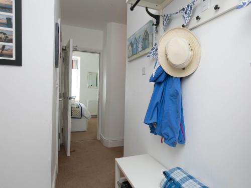 a hallway with a blue umbrella and a hat on a wall at Pass the Keys Modern 2 Bedroom Apartment with stunning Sea Views in Trearddur