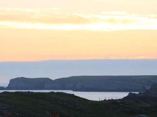 a view of a body of water at sunset at Pass the Keys Modern 2 Bedroom Apartment with stunning Sea Views in Trearddur