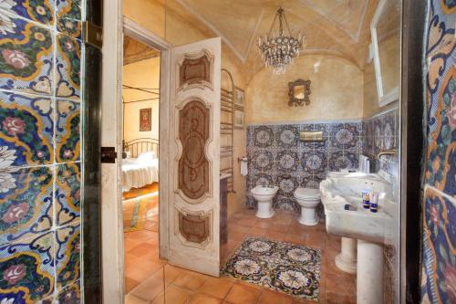 bagno con 2 servizi igienici, lavandino e specchio di Estate4home - Palazzo Crocione a Positano