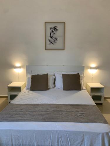una camera da letto con un grande letto con due comodini di Il Canaletto Apartments a Porto Cesareo