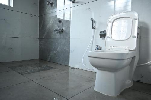 W łazience znajduje się biała toaleta i prysznic. w obiekcie Advaitha Serenity Resorts w mieście Kālvādi