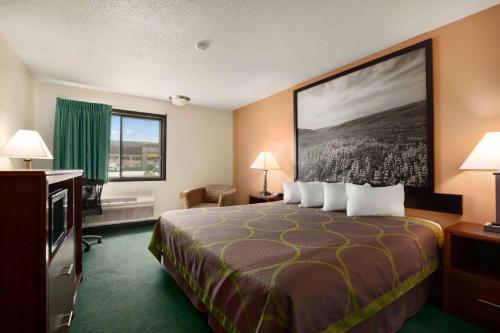 a hotel room with a bed and a large painting on the wall at Super 8 by Wyndham Concordia in Concordia