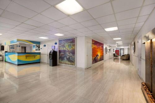 Habitación grande con un pasillo con pinturas en las paredes. en Days Inn by Wyndham Miami International Airport, en Miami