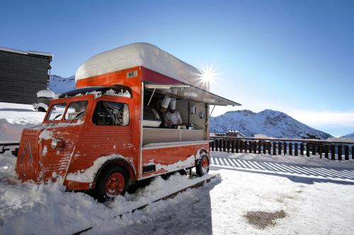 un vieux camion rouge est couvert de neige dans l'établissement Belambra Clubs Avoriaz - Les Cimes du Soleil, à Avoriaz